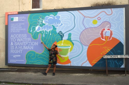 Emma Blake Morsi in front of one of her posters on a billboard in Bristol.